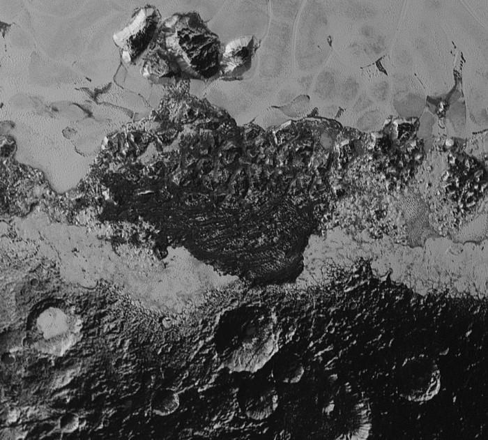 Ce deuxième «zoom» de 350 km de large montre une petite partie de Sputnik Planum en haut et surtout de sombres terrains très accidentés, plus anciens et cratérisés. Par endroits, les scientifiques constatent des «rides» sombres qui pourraient être des dunes. Le conditionnel est de rigueur, car l’atmosphère très peu dense de Pluton (10 000 fois moins que celle de la Terre) peut difficilement expliquer la formation de dunes avec du vent. Crédit : NASA/Johns Hopkins University Applied Physics Laboratory/Southwest Research Institute
