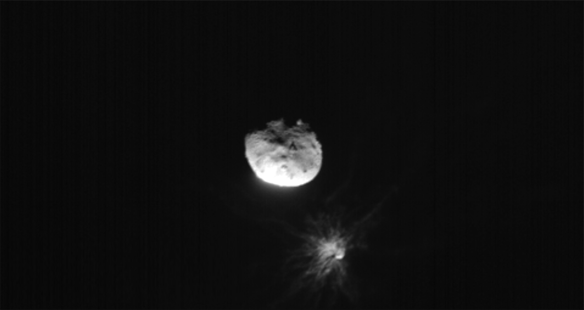 La collision de DART sur Dimorphos le 26 septembre a provoqué un panache de poussière saisi par le petit satellite italien LICIACube largué par la sonde de la NASA quelques jours avant. Au milieu de l’image, l’astéroïde Didymos et dessous Dimorphos. Crédit : ASI/NASA